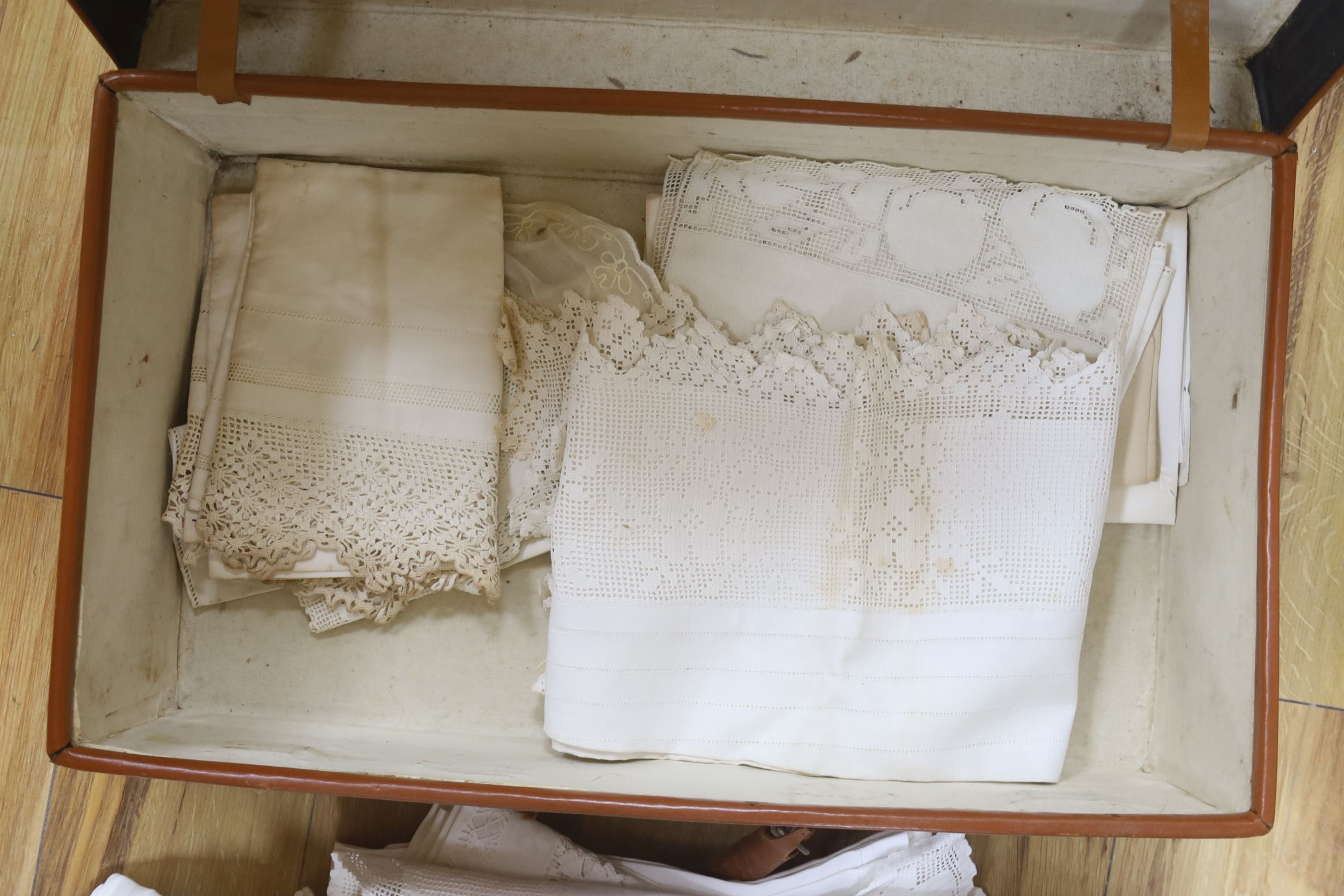 A brown leather suitcase of table linens